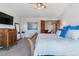 Bright main bedroom featuring a ceiling fan, television, ensuite, artwork, and wood furnishings at 474 Rose Finch Cir, Highlands Ranch, CO 80129