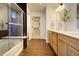Modern bathroom with a dual vanity, walk-in shower, and wood-style flooring at 16357 E 111Th Pl, Commerce City, CO 80022