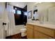 Modern bathroom featuring black tiled walls, a shower-tub combination, and a stylish vanity with a bright mirror at 16357 E 111Th Pl, Commerce City, CO 80022