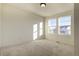 Bright bedroom with ample natural light, plush carpeting, and a view of the neighborhood through large windows at 16357 E 111Th Pl, Commerce City, CO 80022