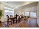 Bright, open-concept living area with hardwood floors, large windows, and stylish dining set adjacent to comfortable living room at 16357 E 111Th Pl, Commerce City, CO 80022
