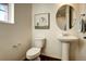 Well-lit half bathroom featuring a pedestal sink, modern fixtures, and stylish decor at 16357 E 111Th Pl, Commerce City, CO 80022