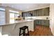 Modern kitchen with an island, counter seating, gray cabinets and stylish countertops at 16357 E 111Th Pl, Commerce City, CO 80022