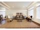 Bright living room with tray ceilings, stylish furniture, and large windows with blinds at 16357 E 111Th Pl, Commerce City, CO 80022