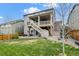 Spacious backyard featuring a well-maintained lawn, patio, and two-story house at 141 Back Nine Dr, Castle Pines, CO 80108