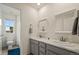 Bathroom featuring double vanity with marble countertop, gray cabinets, and natural light at 141 Back Nine Dr, Castle Pines, CO 80108