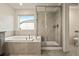 Relaxing bathroom featuring a tub and a separate glass-enclosed shower providing a spa-like experience at 141 Back Nine Dr, Castle Pines, CO 80108