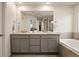 Modern bathroom featuring a granite double sink vanity and a soaking tub for a comfortable experience at 141 Back Nine Dr, Castle Pines, CO 80108