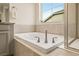 Bright bathroom featuring a soaking tub beneath a window offering a peaceful retreat at 141 Back Nine Dr, Castle Pines, CO 80108