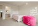 Bright bedroom with a white frame bed, pink beanbag chair, and unique neon wall decor at 141 Back Nine Dr, Castle Pines, CO 80108