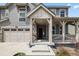 Inviting front entrance with covered porch featuring detailed woodwork, stone accents, and a multi-car garage at 141 Back Nine Dr, Castle Pines, CO 80108
