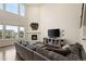 Open living room boasts high ceilings, ample natural light, and cozy fireplace at 141 Back Nine Dr, Castle Pines, CO 80108