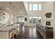 Open-concept living room with soaring ceilings, large windows, modern fireplace, and seamless flow to the kitchen at 141 Back Nine Dr, Castle Pines, CO 80108