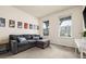 Cozy living room with a gray sofa, an ottoman, movie posters, and bright windows at 141 Back Nine Dr, Castle Pines, CO 80108