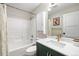 Cozy bathroom with a shower-tub combo, stylish vanity, a gold faucet, and white tile, blending functionality with style at 11777 Elizabeth Cir, Thornton, CO 80233