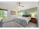 Sunlit bedroom with a ceiling fan, a comfortable bed, natural wood accents and soothing green wall, creating a serene ambiance at 11777 Elizabeth Cir, Thornton, CO 80233