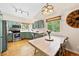 Eat-in kitchen featuring hardwood floors, stainless steel appliances, and green cabinets at 11777 Elizabeth Cir, Thornton, CO 80233