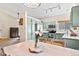 Bright kitchen boasts modern appliances, light green cabinetry, and natural light, creating a warm, inviting space at 11777 Elizabeth Cir, Thornton, CO 80233