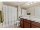 Bright bathroom featuring shower-tub combo with white shower curtain and wooden vanity at 17956 Gypsum Canyon Ct, Monument, CO 80132