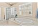 Bright bathroom showcasing a glass-enclosed shower and large soaking tub with tile surround at 17956 Gypsum Canyon Ct, Monument, CO 80132