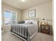 Inviting bedroom with a metal bed frame, neutral-toned decor, and a window with neighborhood views at 17956 Gypsum Canyon Ct, Monument, CO 80132
