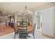 Open-concept dining area featuring a round table, modern chandelier, and access to the outdoor area at 17956 Gypsum Canyon Ct, Monument, CO 80132