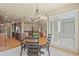 Open-concept dining area featuring a round table, modern chandelier, and access to the outdoor area at 17956 Gypsum Canyon Ct, Monument, CO 80132