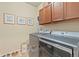Well-equipped laundry room with modern washer and dryer, overhead cabinets, and stylish decor at 17956 Gypsum Canyon Ct, Monument, CO 80132