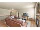 Open-concept living room with hardwood floors, a stone fireplace, and comfortable leather sofas at 17956 Gypsum Canyon Ct, Monument, CO 80132