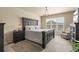 Spacious main bedroom featuring a dark wood bed frame, carpeted floors, and a bright window at 17956 Gypsum Canyon Ct, Monument, CO 80132