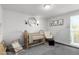 Bedroom features a wood crib, chair, neutral tones, and decorative wall art at 6450 Tennyson St # 1, Arvada, CO 80003