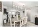 Dining area open to the kitchen, featuring a modern light fixture and staircase nearby at 6450 Tennyson St # 1, Arvada, CO 80003