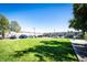 A grassy lawn outside of the community with a basketball court and playground in the distance at 6450 Tennyson St # 1, Arvada, CO 80003