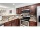 Modern kitchen with stainless appliances, granite counters, and dark cabinets with sleek hardware at 6450 Tennyson St # 1, Arvada, CO 80003