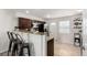 Kitchen featuring barstool seating, granite counters, dark cabinets, and stainless appliances at 6450 Tennyson St # 1, Arvada, CO 80003