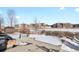View of backyard with snowy ground and school in the distance at 581 N Flat Rock Cir, Aurora, CO 80018