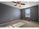 This cozy bedroom offers a ceiling fan, natural light, and neutral-colored carpet at 581 N Flat Rock Cir, Aurora, CO 80018
