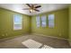This bedroom offers three bright windows, neutral-colored carpet, and a ceiling fan at 581 N Flat Rock Cir, Aurora, CO 80018