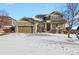 Two-story house with green and brown siding, stone accents, and a three-car garage at 581 N Flat Rock Cir, Aurora, CO 80018