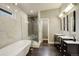 Modern bathroom featuring a soaking tub, glass-enclosed shower, double vanity, and sleek tile flooring at 2624 S Race St, Denver, CO 80210