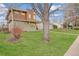 Beautifully landscaped front yard with green grass and mature trees creating a serene setting at 2624 S Race St, Denver, CO 80210