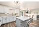 Contemporary kitchen with white cabinets, stainless appliances, island, and breakfast bar seating at 23813 Broadmoor Dr, Parker, CO 80138