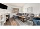 Inviting living room with a cozy fireplace, plush gray sofa, and warm wood floors at 23813 Broadmoor Dr, Parker, CO 80138