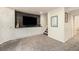 Entertainment area featuring a large TV on wood wall paneling with white cabinets and nearby staircase at 23813 Broadmoor Dr, Parker, CO 80138