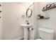 Stylish powder room with pedestal sink, decorative mirror, and modern fixtures at 23813 Broadmoor Dr, Parker, CO 80138