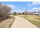 A paved walking path winds through a park setting, with amenities like a pool and playground nearby at 23813 Broadmoor Dr, Parker, CO 80138