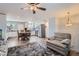Spacious living room with neutral tones, ceiling fan, and cozy chair next to a staircase at 14798 E Temple Dr, Aurora, CO 80015