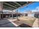 A spacious backyard featuring a covered patio with string lights, shed, and well-kept grass at 865 S Dale Ct, Denver, CO 80219