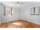 Bright bedroom features hardwood floors, neutral walls, ceiling fan, and two windows at 865 S Dale Ct, Denver, CO 80219