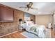 Cozy bedroom featuring a brick wall, a ceiling fan, and comfortable furnishings at 865 S Dale Ct, Denver, CO 80219
